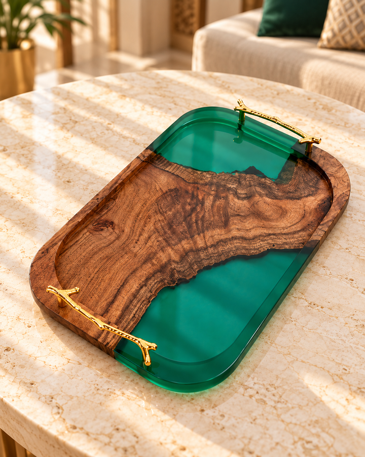 Wood and emerald epoxy resin serving tray with gold branch handles on a marble table